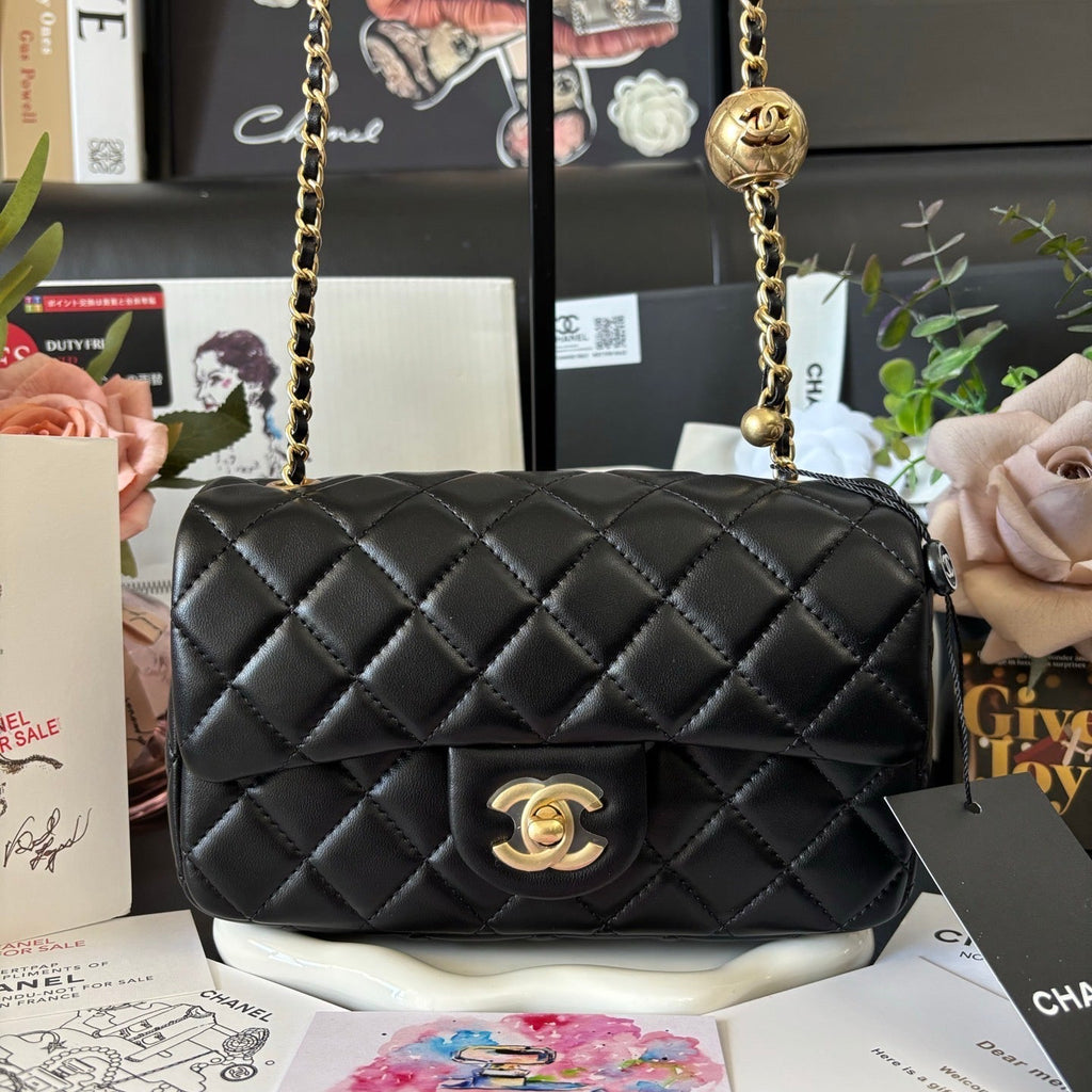 Black quilted handbag with gold chain vip novelty bag with Chanel makeup branding.